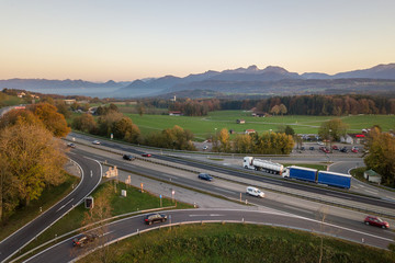 Top down aerial view of freeway interstate road with moving traffic cars in rural area.