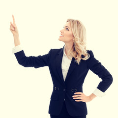 Happy smiling businesswoman in confident style black suit, showing something, some product or blank...