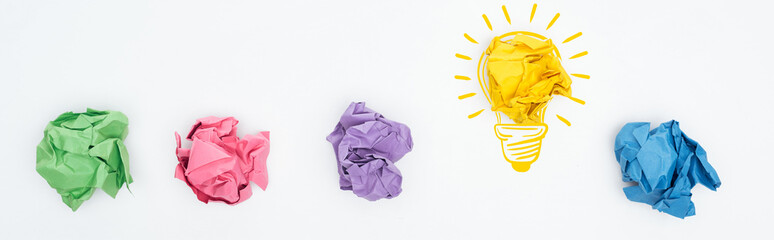 panoramic shot of multicolored crumpled paper balls and light bulb illustration on white background, business concept