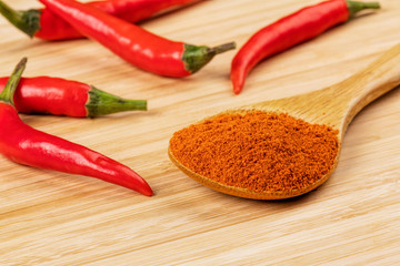 Spoon full of Chili Powder on a wooden background