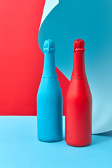Wine bottles mock-up painted red and blue on a duotone curly background.