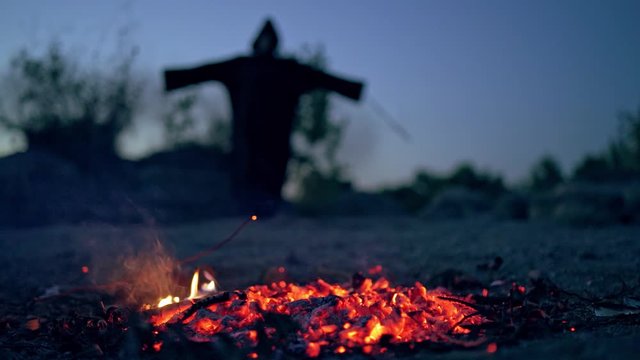 Fairy tales on Halloween. Landscape night forest view with witch standing near bonfire