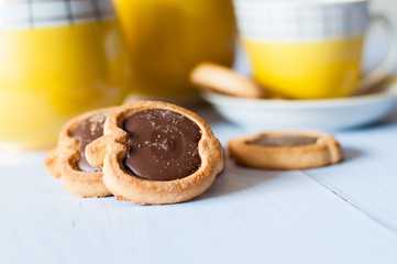 Tasty sweet cookies with chocolate, cup of espresso and a vintage coffee set with a spoon