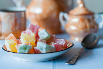 Multicolored Turkish delight, oriental sweets, close-up and very beautiful, vintage, old coffee set and spoon