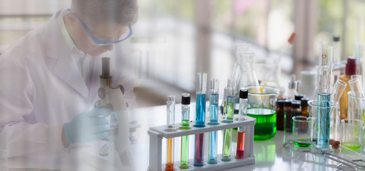 Laboratory concept: glassware in a chemical laboratory with a blurred background of the scientist in a white coat