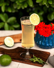 a glass of lime juice garnished iwth ice and lime slice