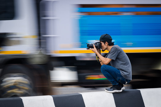 Samut Sakhon, Thailand - June 2019: Street photographers are taking pictures of running cars on on Rama 2 Road on June 2, 2019 at Samut Sakhon, Thailand.