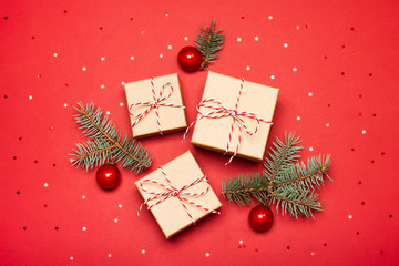 Christmas composition with gifts, branches and holiday elements on the red background. Flat lay. Merry Christmas, New Year, winter concept.