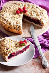 Homemade berry shortcrust pie with crumble on wooden board
