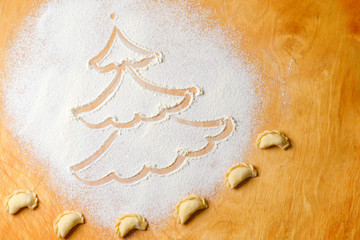 Drawing of a Christmas tree on a cutting Board made of white flour