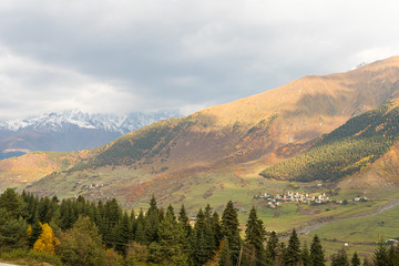 Early  morning view of a small village located at the foot of the mountains against the backdrop of snow-capped peaks in Svaneti in the mountainous part of Georgia