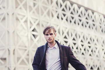 handsome fashionable man in a jacket and white shirt in urban style