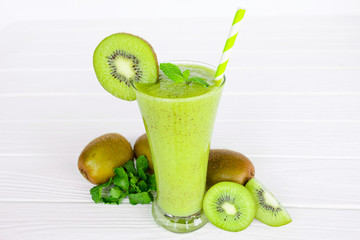 Kiwi yogurt fruit juice smoothie and green kiwi juice drink healthy, delicious taste in a glass for weight loss on a white wooden background.