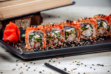 close up of california roll topped with red tobiko
