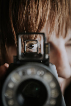 Close up of woman looking through camera viewfinder