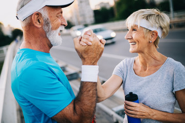 Fitness, sport, people, exercising and lifestyle concept - senior couple running