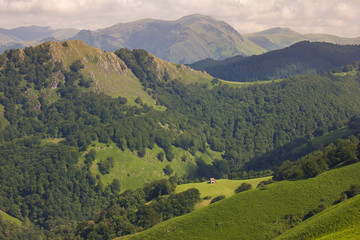 Obraz premium Mountain landscape, green valley. Tiny rural house on the top of the mountains in the French Pyrenees. Landscape on the trail of Napoleon from France to Spain. French Way of Saint James.