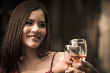 Young happy woman drinking holding and drinking a glass of alcohol at night bar or night Club, night party celebrations concept.