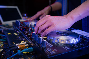 Sound engineer on mixer, close up of DJ hands on stage mixing, disc jockey and mix tracks on sound...