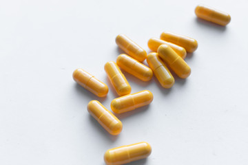 Scatterded yellow pills on white background 