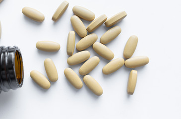 Scatterded yellow pills on white background 