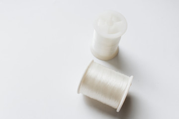 White sewing threads background closeup