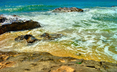 Beautiful landscape with rocks and sea waves on a sunny beach