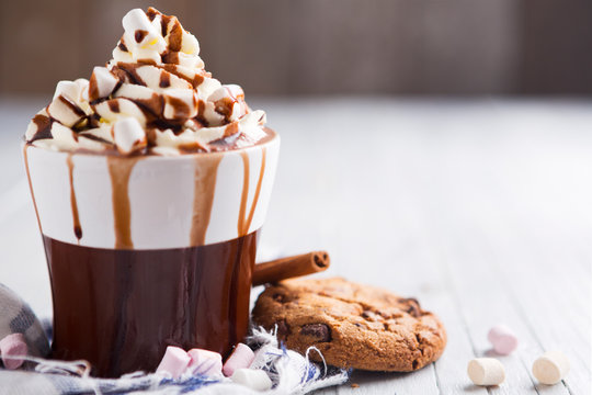 Messy hot chocolate, cream and marshmallows and a choc-chip cookie