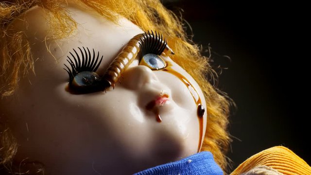 Horrible worm on the face of vintage creepy doll. Phobia and fear concept.