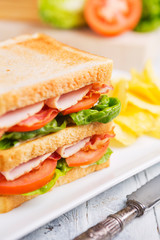 Club sandwich on a rustic table in bright light