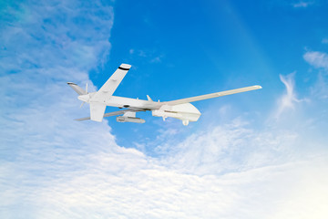 .military RC military drone flies against the backdrop of blue peaceful sky with white clouds