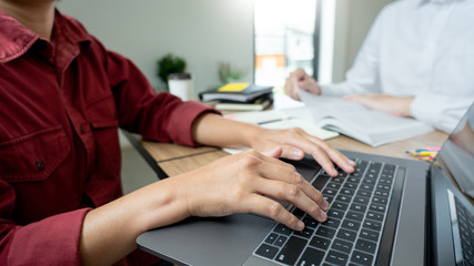 Teaching helping technology concept. Woman young teacher or tutor with adult students in classroom...