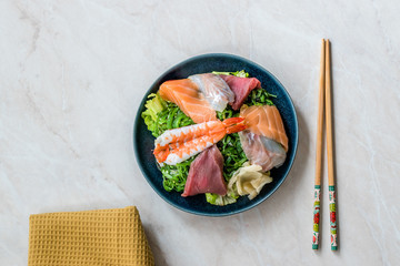 Sashimi Salad with Wakame, Seaweed, Salmon, Sea Bass, Shrimp, Kani, Mackerel Fish, Tuna served with Chopsticks.