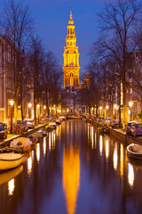 Naklejka premium Church and a canal in Amsterdam at night