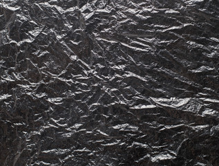 Crumpled black polyethylene texture with highlights