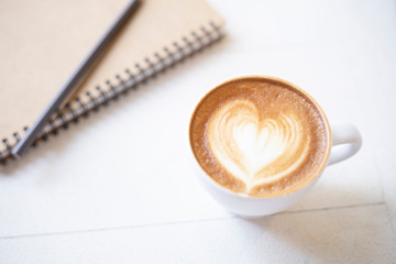 coffee cup with notebook on table