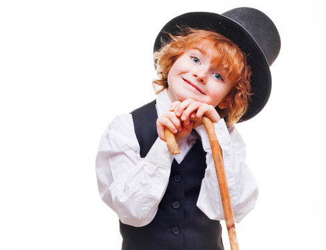 kid actor in the theatre, stylish boy in hat isolated on white background, happy child actor with a cane in his hand dressed in a black suit, talented red curly boy playing in the theatre