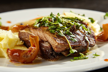 Beef brisket and mashed potato on white plate