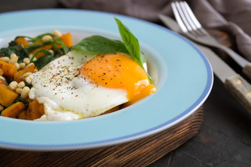 Sunny side up egg with spinach and pumpkin.