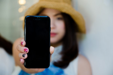 asian girl is showing black smartphone
