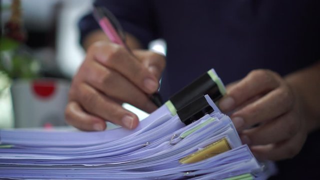 Businessman hands working in stacks documents of paper files, searching information on desk office, Accounting budget report file, check working for arranging unfinished of paperwork on busy office