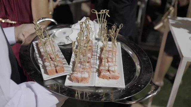 Aprende a pronunciarWaiter serving food in a cocktail, canapes, at night at a party