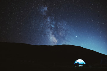Illuminated camping tent under stars at night. nature reserve Sochi - obrazy, fototapety, plakaty