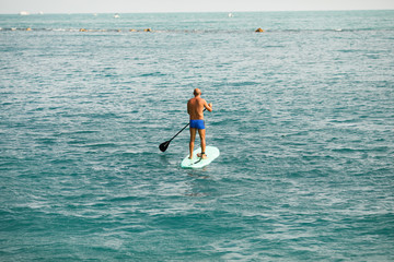 Man floating on a Paddle boards