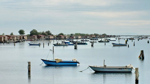 Fishing huts and boats in the Delta del Po, Veneto, Italy. 