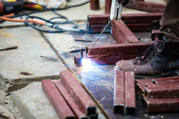 Man Worker welding metal at construction site