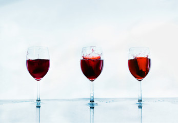  Three wine glasses with water stop and reflection on an abstract white background