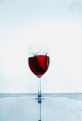 A glass of red wine and wine stops on an abstract background with reflection