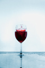 A glass of red wine and wine stops on an abstract background with reflection