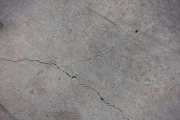 Cracked light grey concrete slab from above
